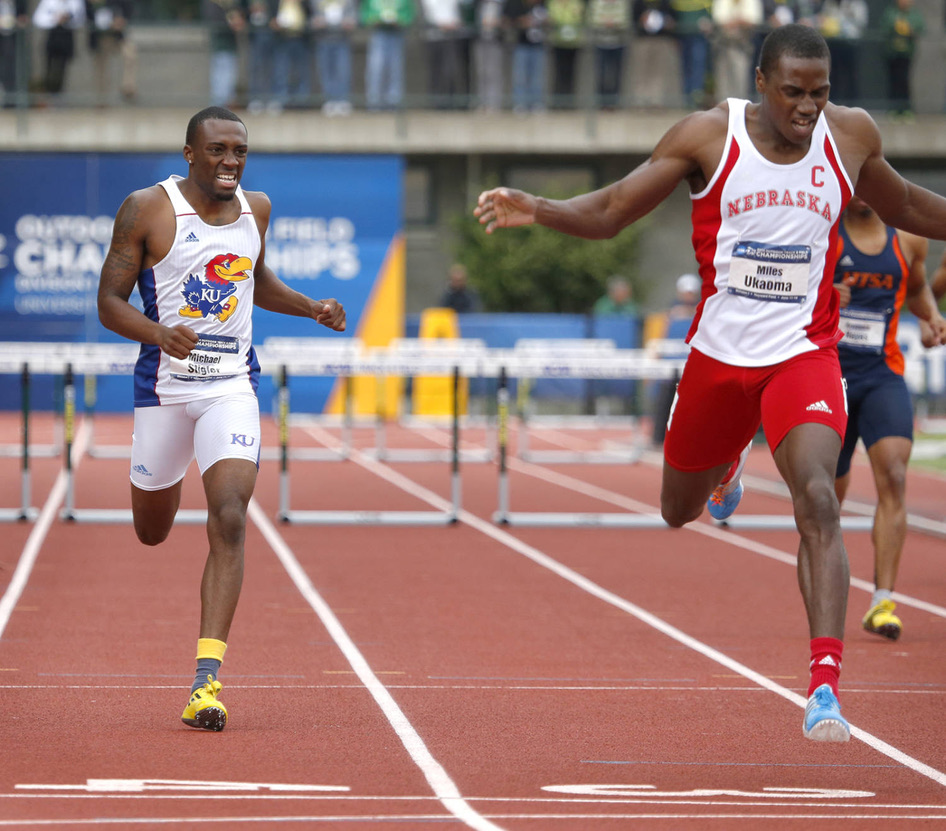Miles Ukaoma in a scarlet Nebraska singlet racing the 400m hurdles