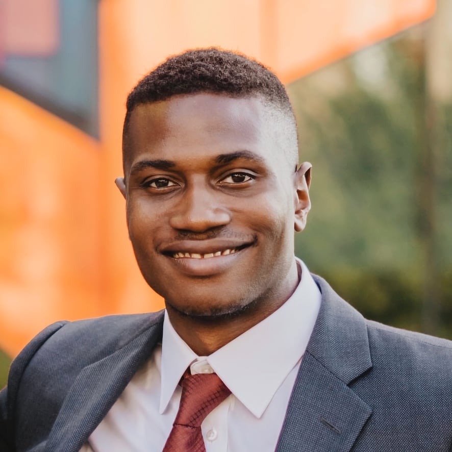 Miles Ukaoma in a tailored grey suit, corporate headshot