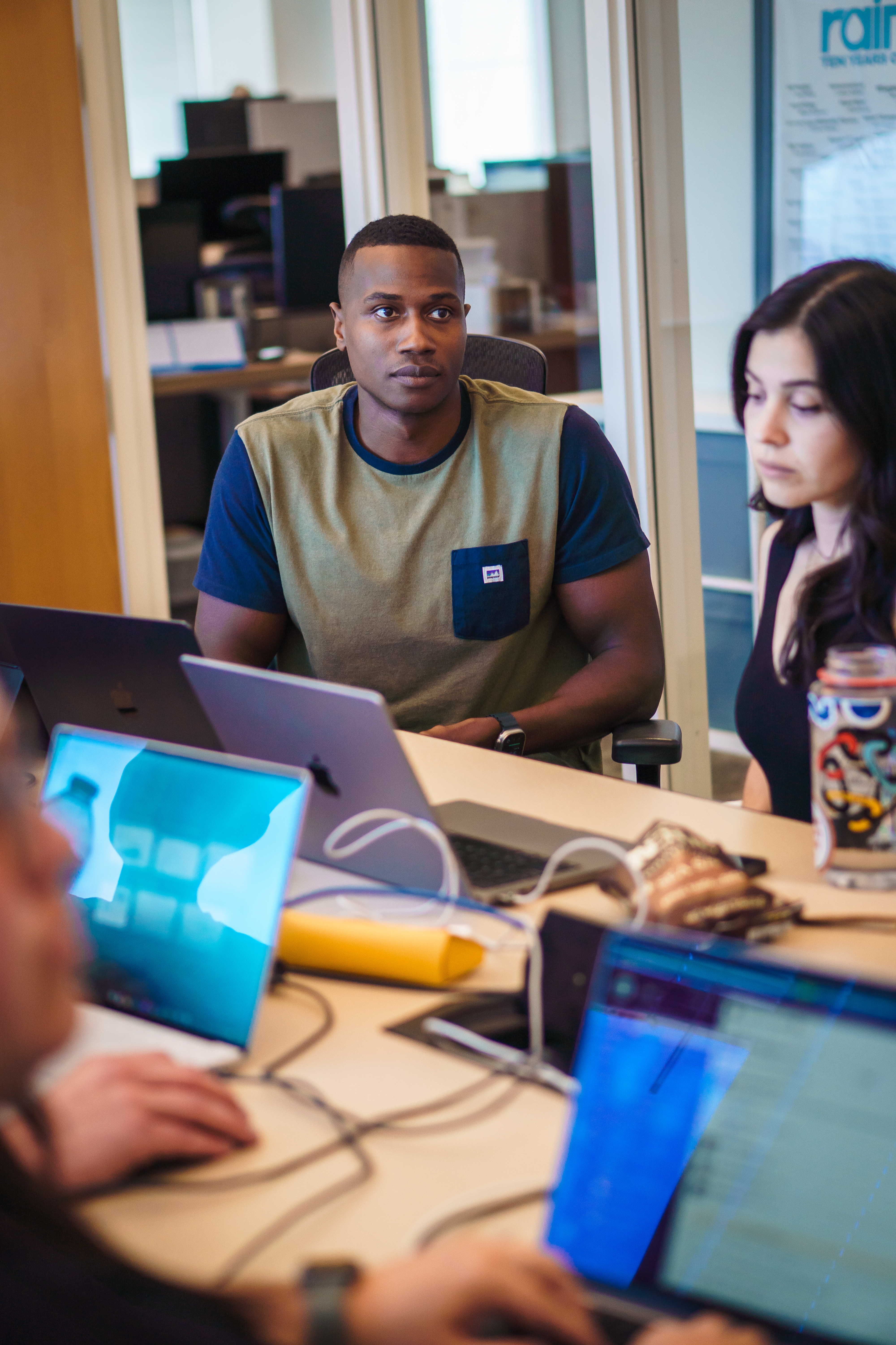 Miles Ukaoma at a working session desk with a teammate, laptops open